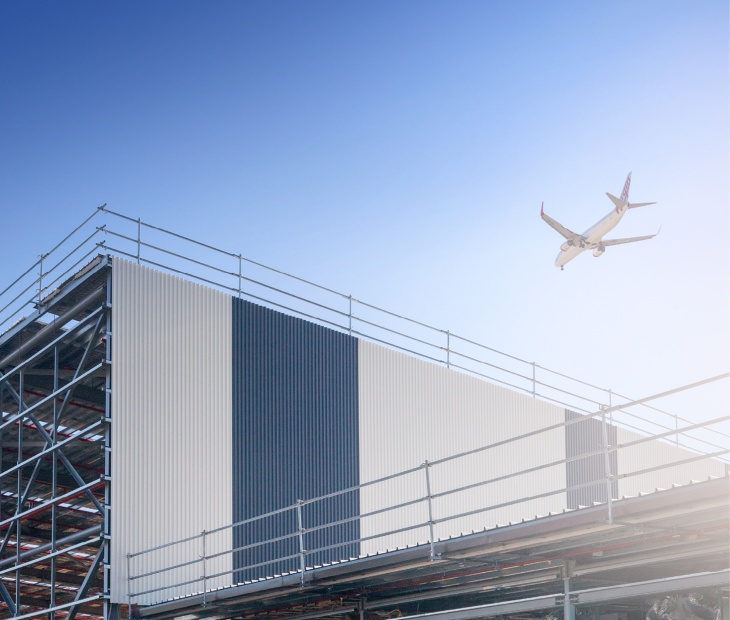Plane flying over building - Brisbane Airport