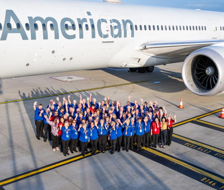 Group photo of Airport Ambassadors infront of American Airlines plane
