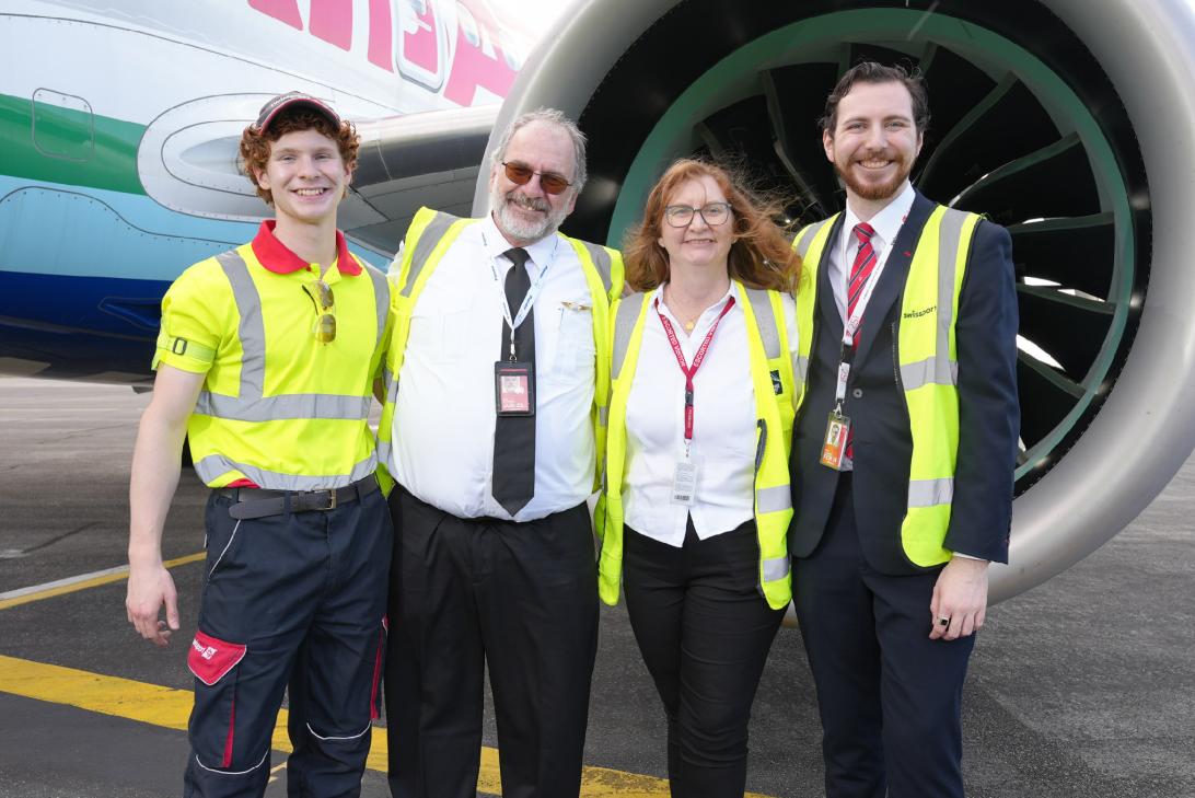 Family of four in yellow high-vis in front of a jet engine